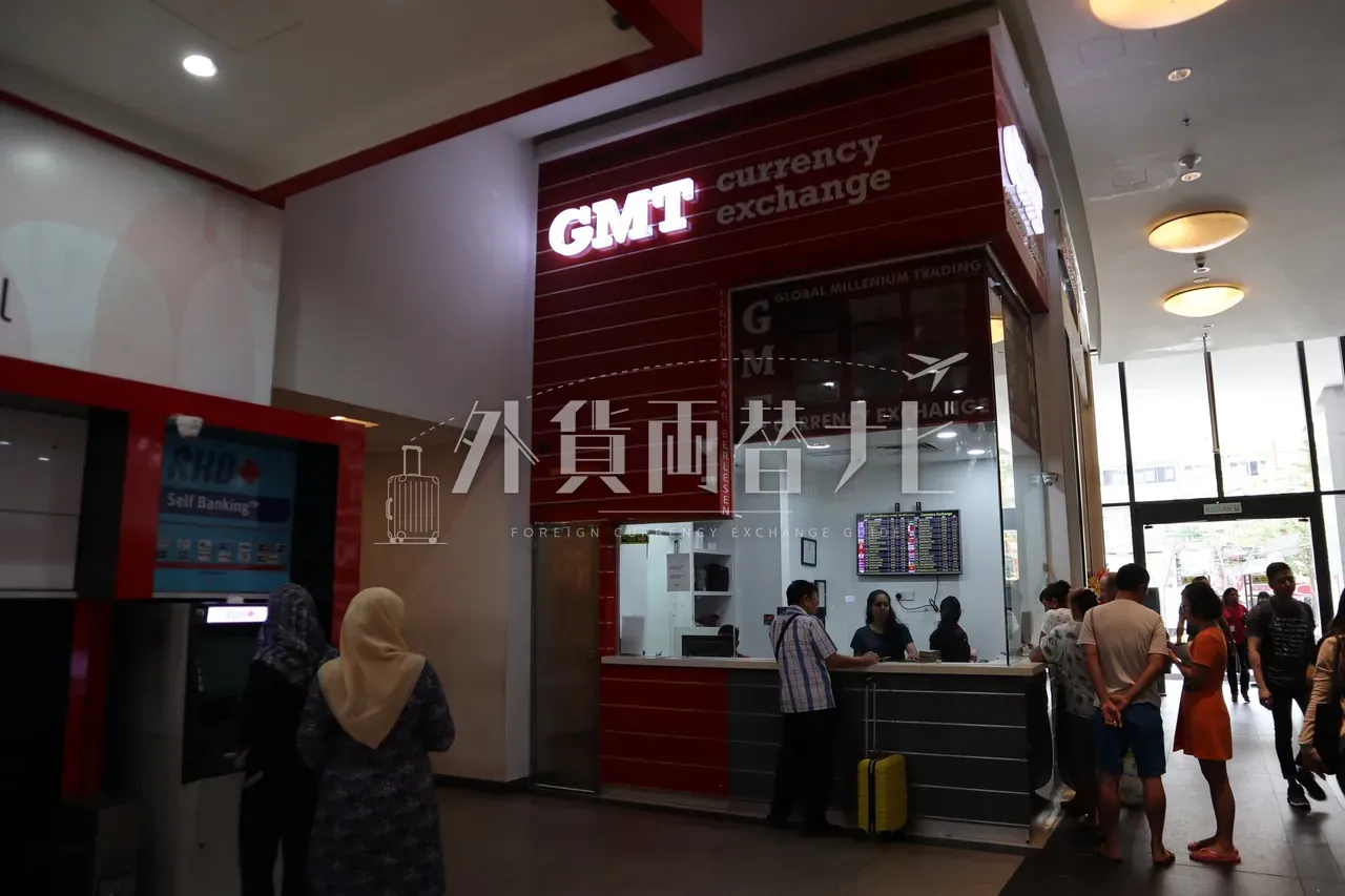 NU Sentral モール内の赤いキオスク型両替店 GMT currency exchange に並ぶ利用客と隣接する RHB Self Banking ATM