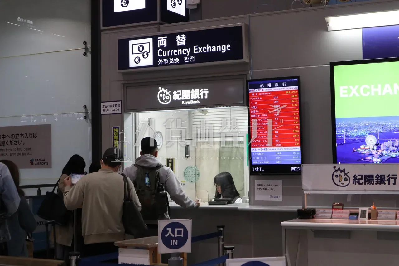 関西国際空港の紀陽銀行の両替カウンターのレートボードと並ぶ旅行者の列