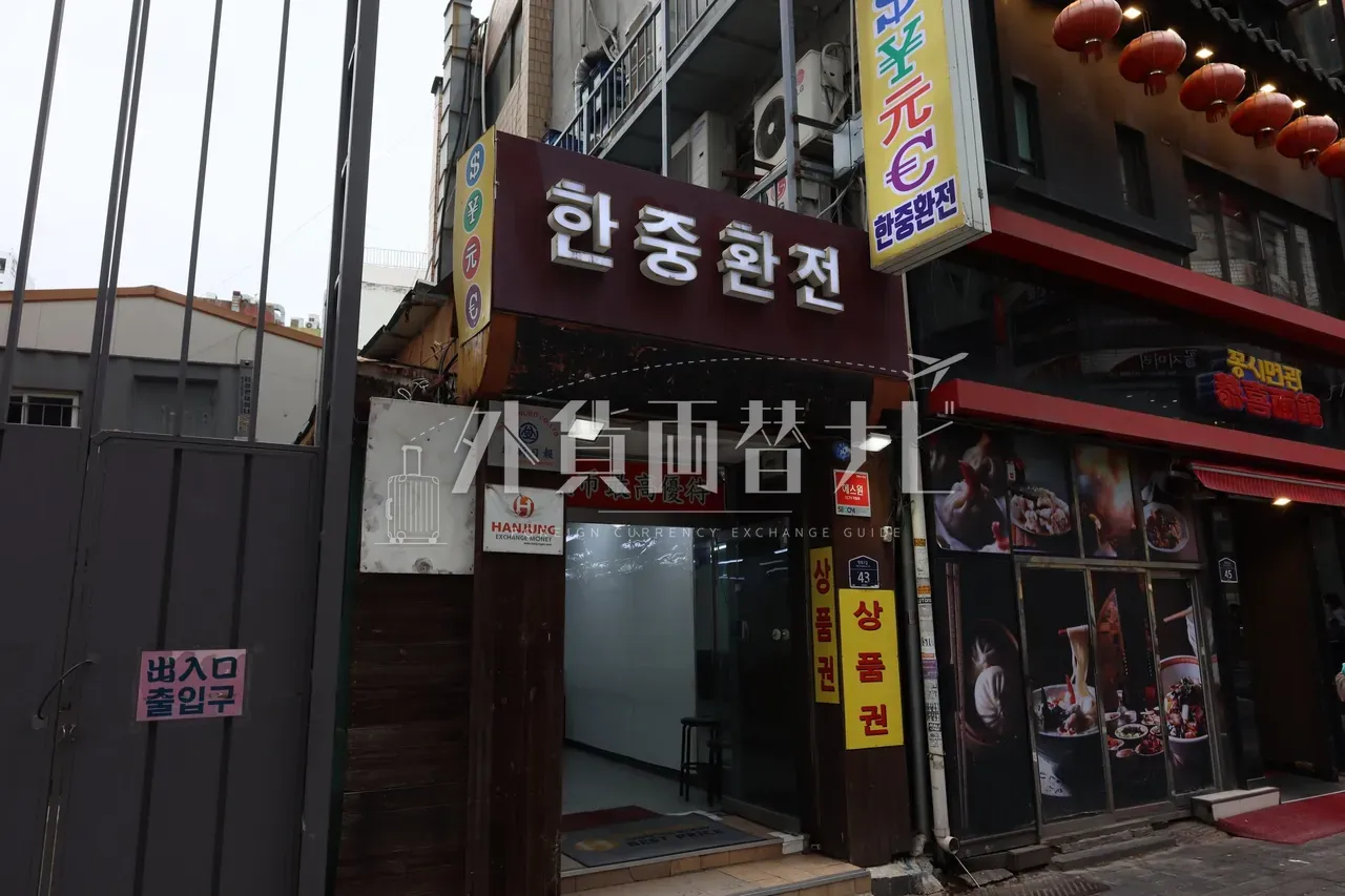 明洞の韓中換銭（HANJUNG EXCHANGE）店外観。通貨記号パネルと「市最高優待」の看板