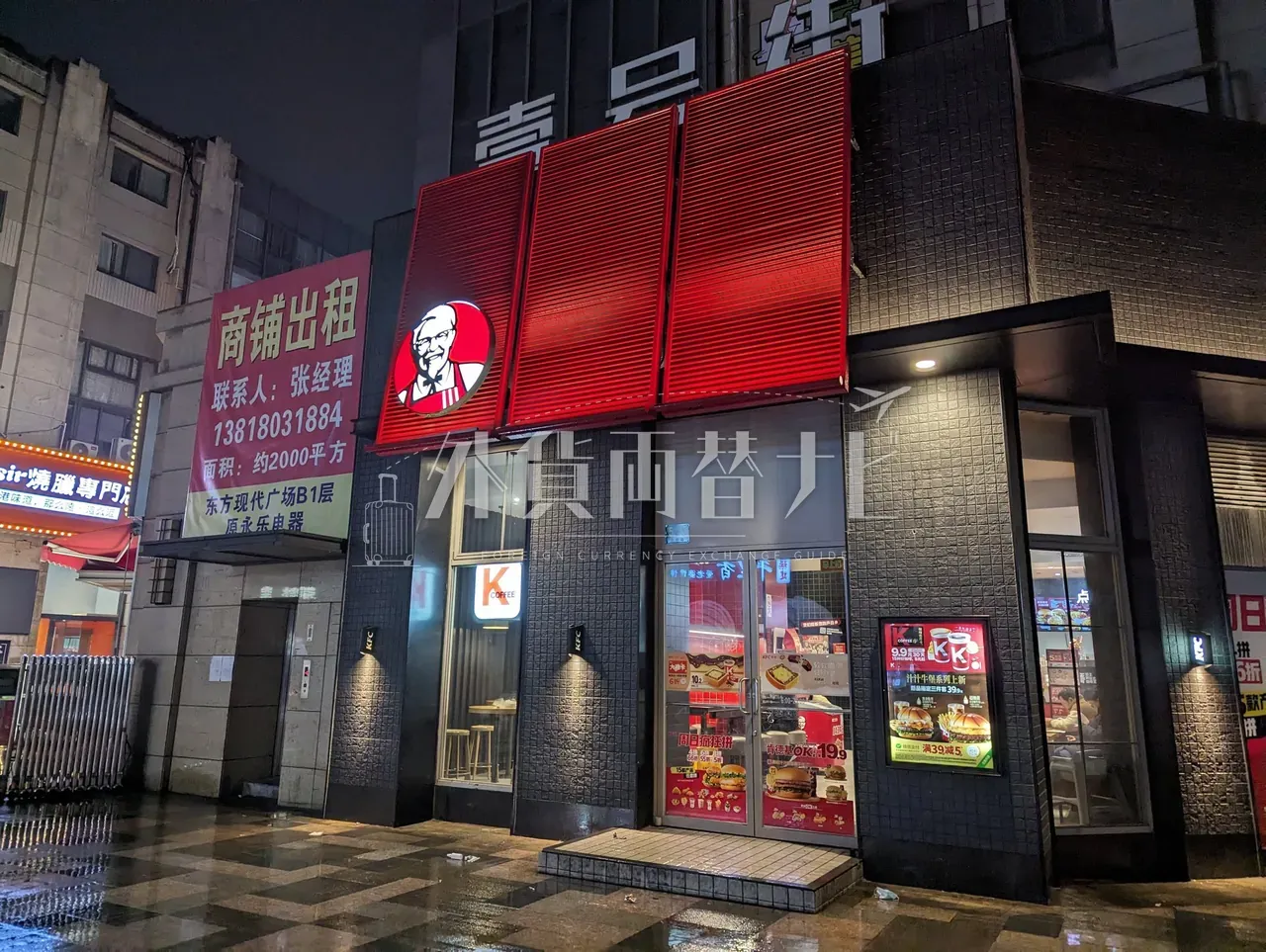 雨上がりの上海の街角に灯る赤いKFCの看板