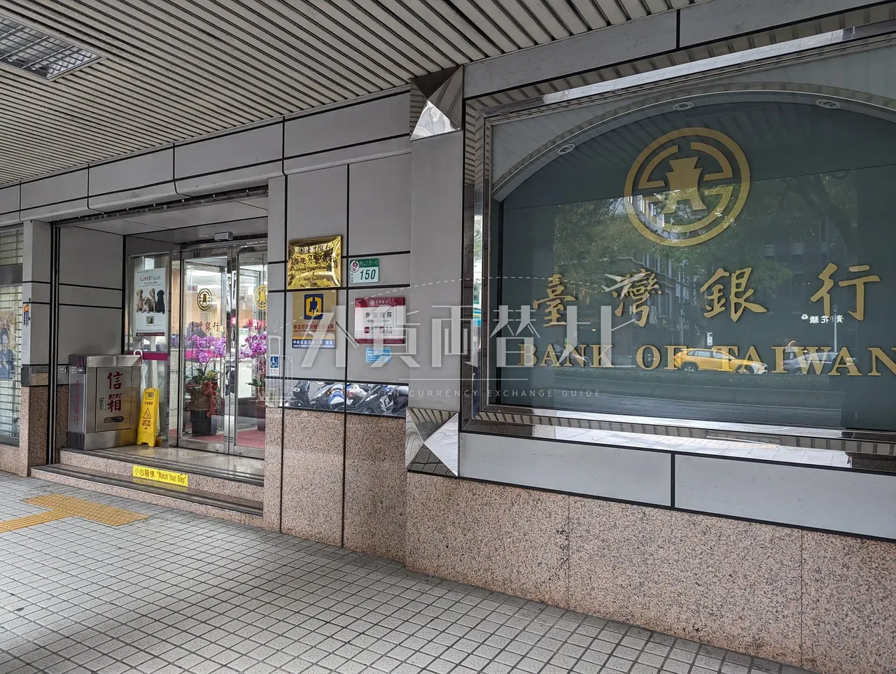 台湾銀行支店の入口外観、緑文字の臺灣銀行窓ガラスが特徴