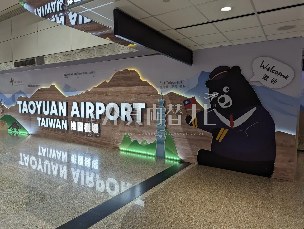 桃園空港ターミナルのウェルカム壁画と台湾黒熊キャラクター。TAOYUAN AIRPORT の文字