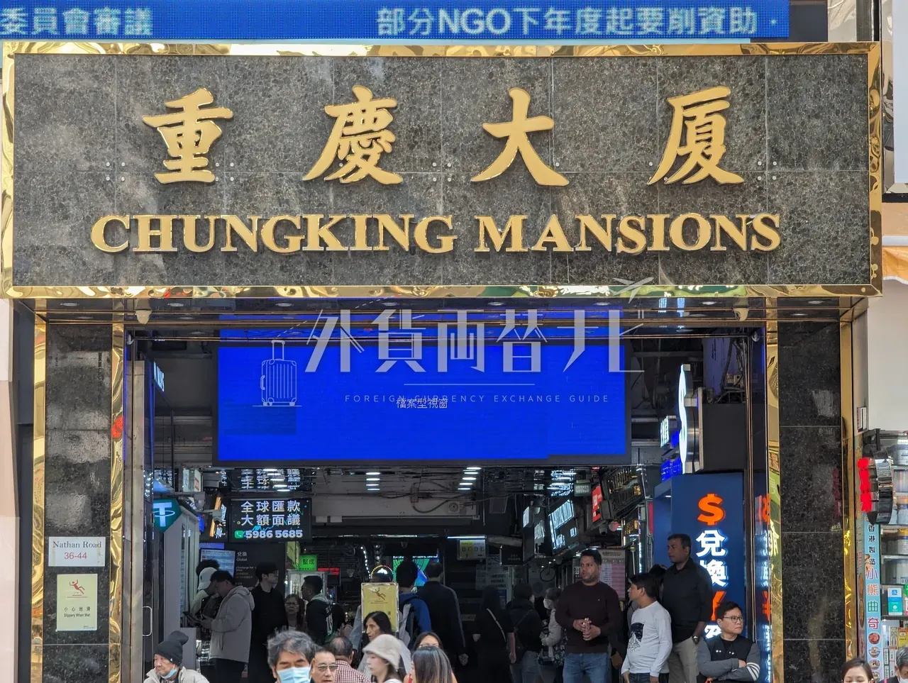 尖沙咀ネイザンロード沿いの重慶大廈 CHUNGKING MANSIONS 正面玄関を見上げた構図、両替店サインが並ぶ