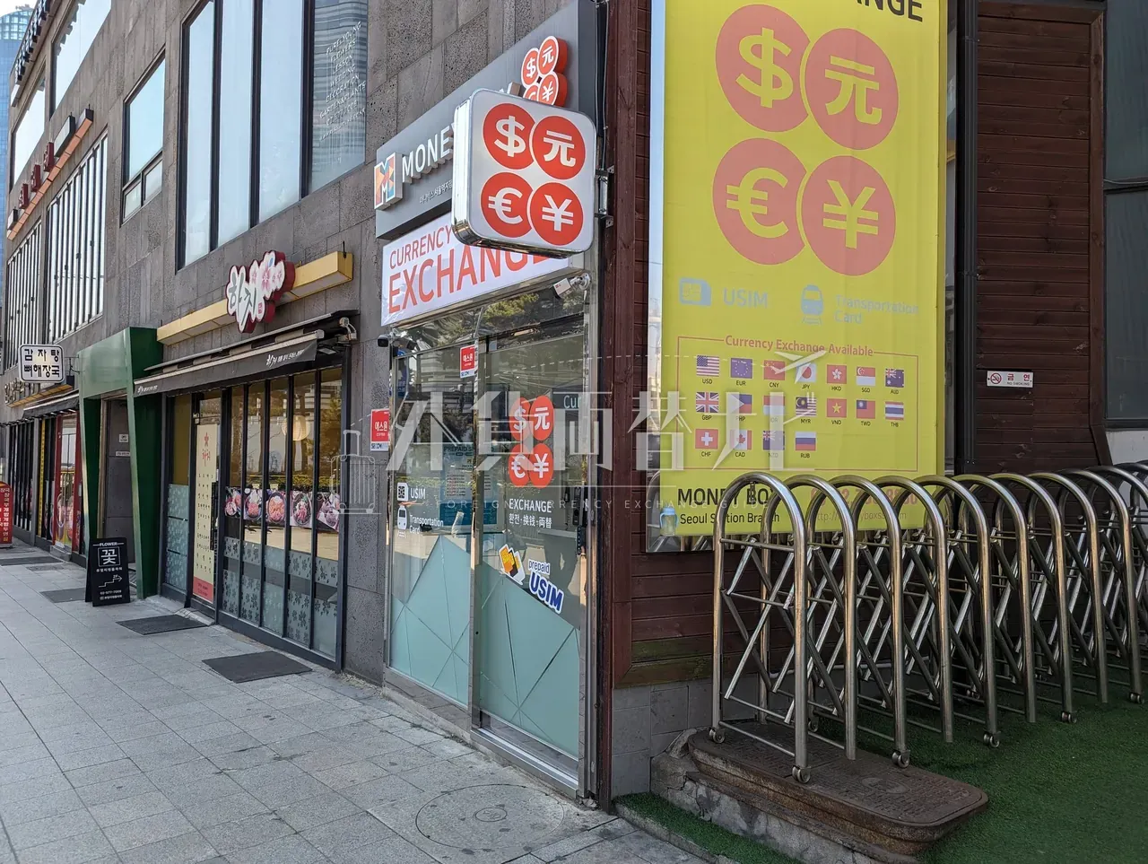 ソウル駅前の MoneyBox 外観。$€¥元の通貨記号が入った大型看板