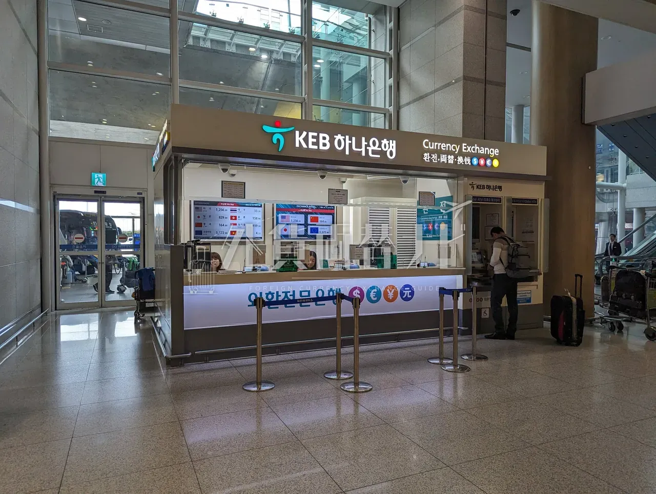 仁川空港の「KEB하나은행 KEB HANA BANK」両替カウンターで手続き中の客 1 名